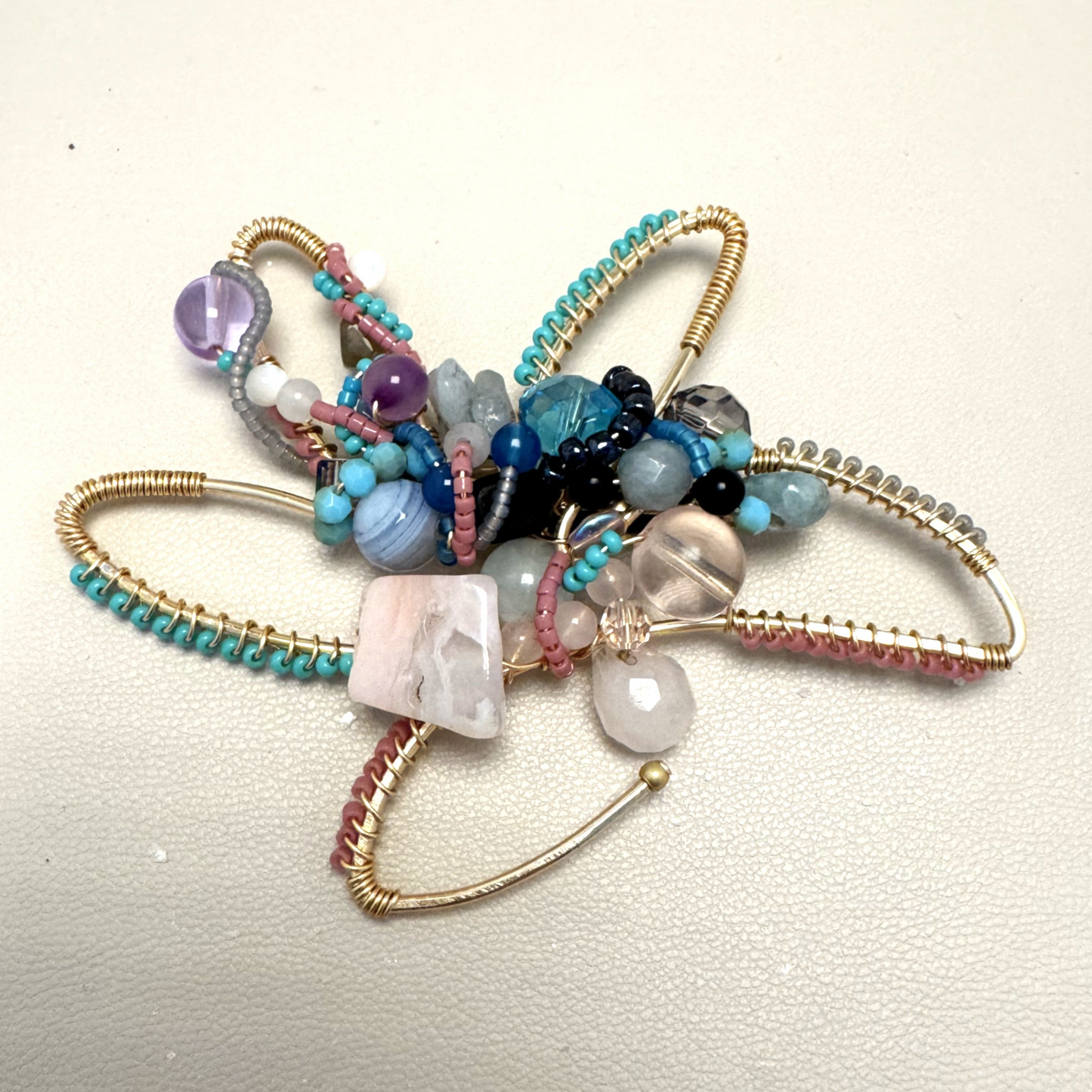 Multicolored beaded artisan flower on a light background