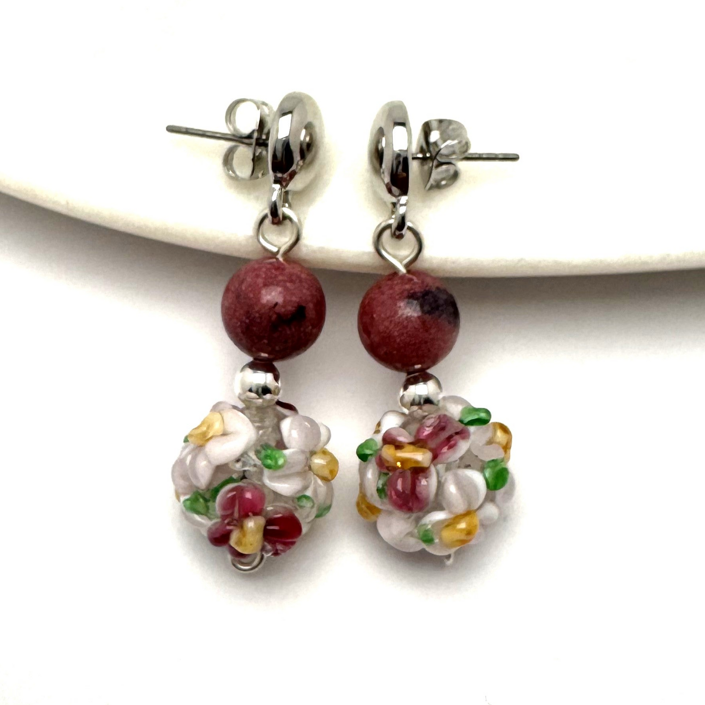 Handmade Floral Elegance Earrings featuring intricate floral lamp work glass beads and soft pink rhodonite accents. A romantic and meaningful accessory, perfect as a gift or personal statement piece.