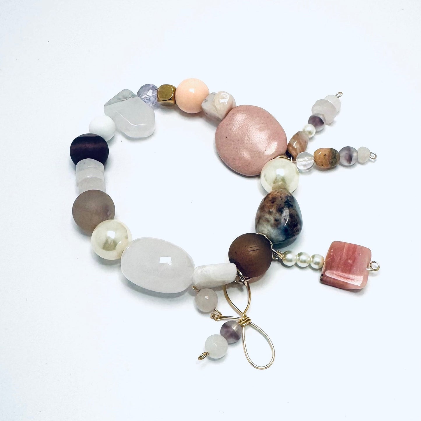 A handcrafted bracelet featuring sodalite, pink opal, rose quartz, and agate in soft pink tones. Designed for stacking or wearing alone, this boho-inspired piece is believed to promote love, healing, and creativity. Handmade in Canada.