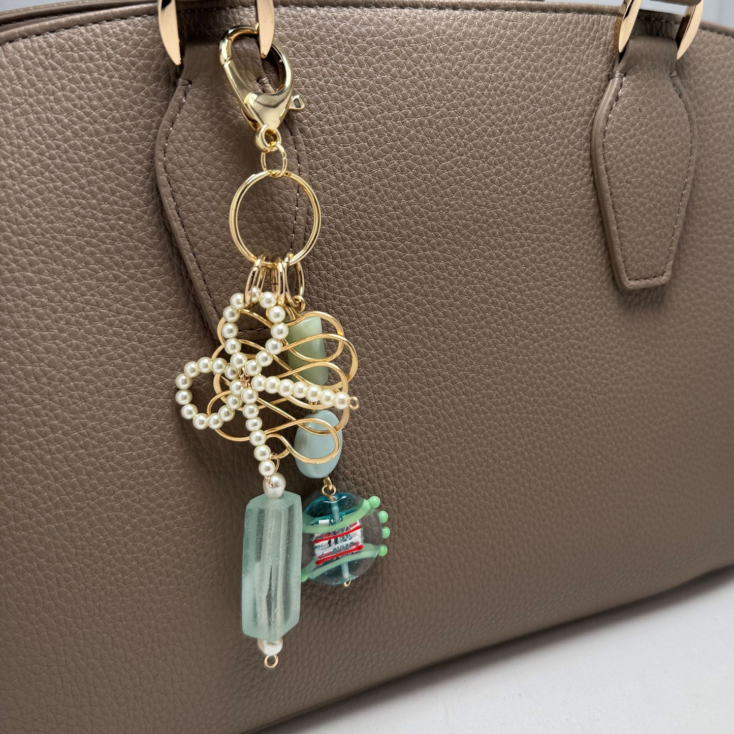 Handmade purse accessory with sea glass, lamp work bead, gold wire and pearl bow. Clip to bags, backpacks, jean loop or belts. (Pearl, Serpentine and glass)