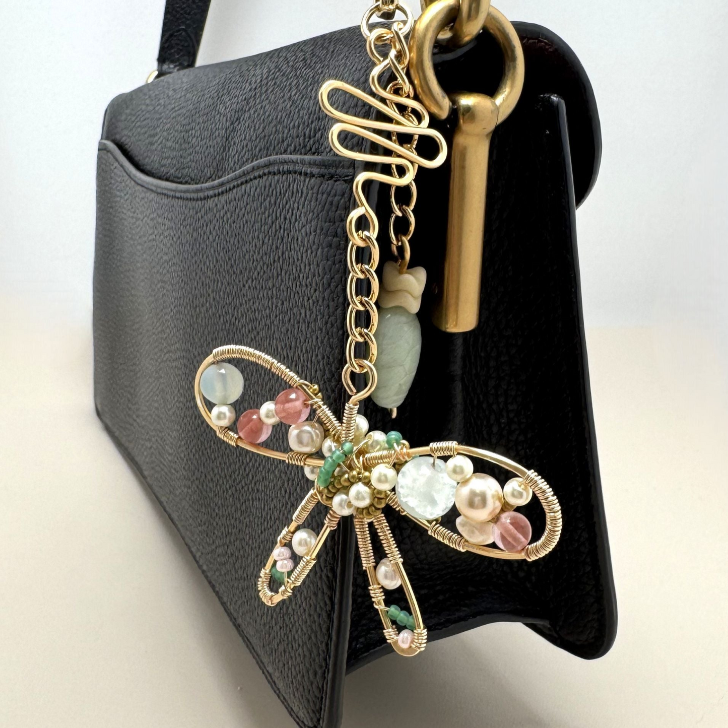 Handmade stylized butterfly purse charm with forged wire, glass, and vintage beads, clipped to a handbag with lobster clasp.