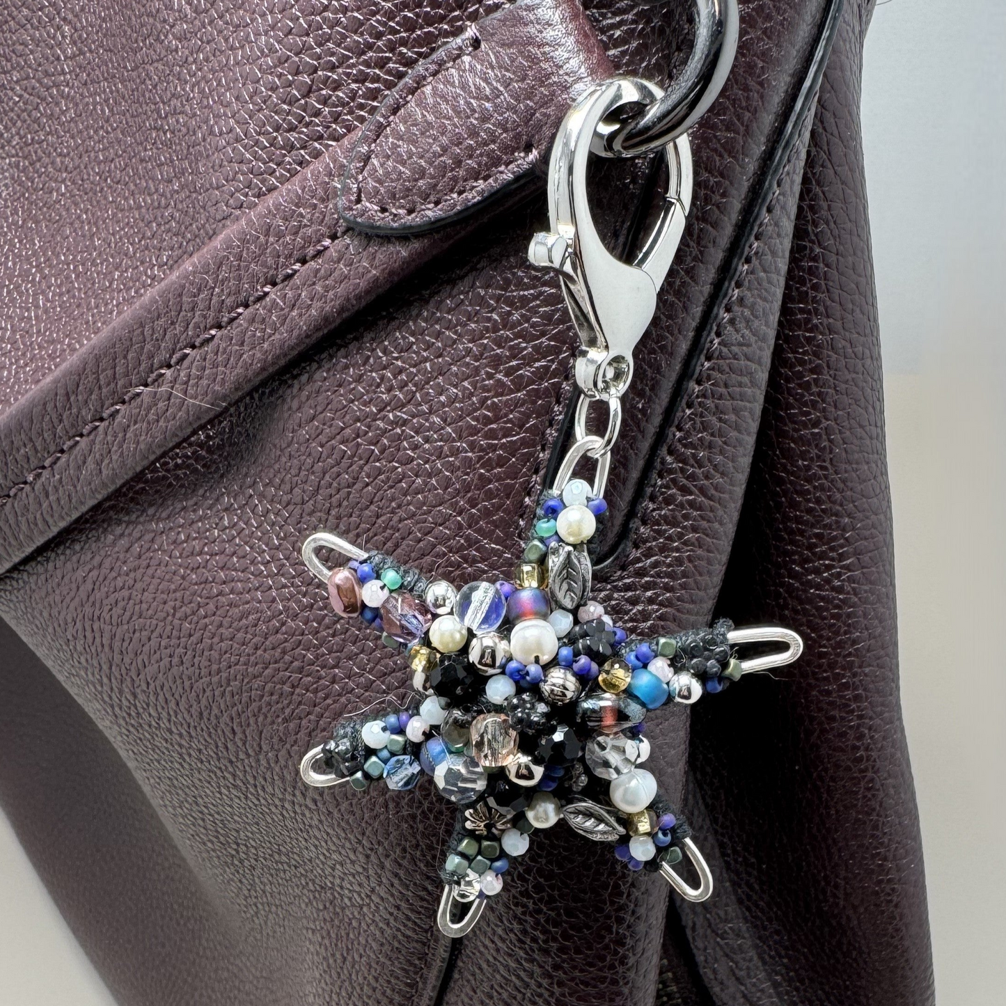 Handmade beaded star purse charm with shimmering glass beads and a lobster clasp for easy attachment.