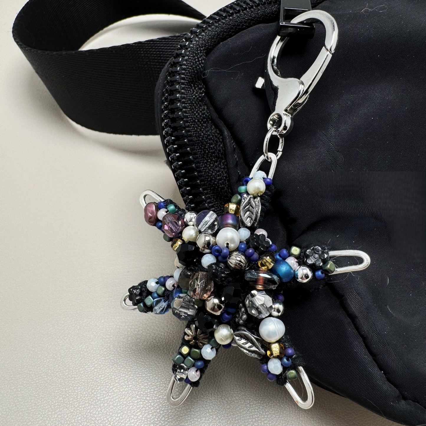 Handmade beaded star purse charm with shimmering glass beads and a lobster clasp for easy attachment.