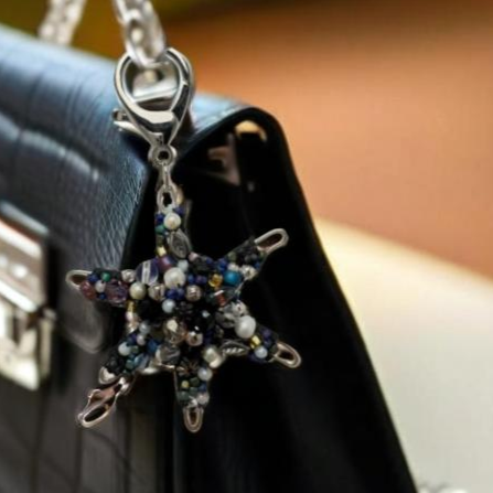 Handmade beaded star purse charm with shimmering glass beads and a lobster clasp for easy attachment.