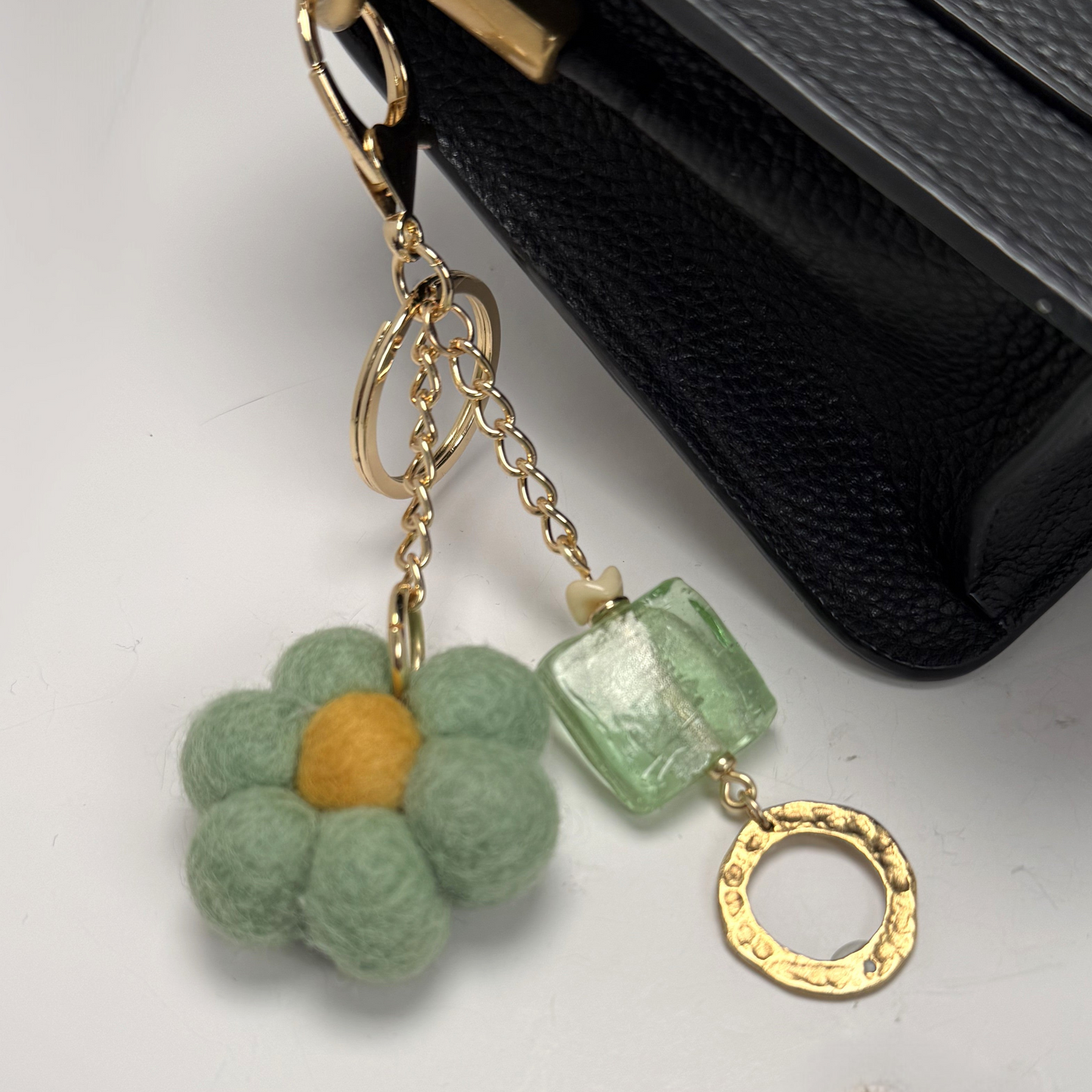 Handmade felted flower purse charm and keychain with vintage glass bead clipped to purse.
