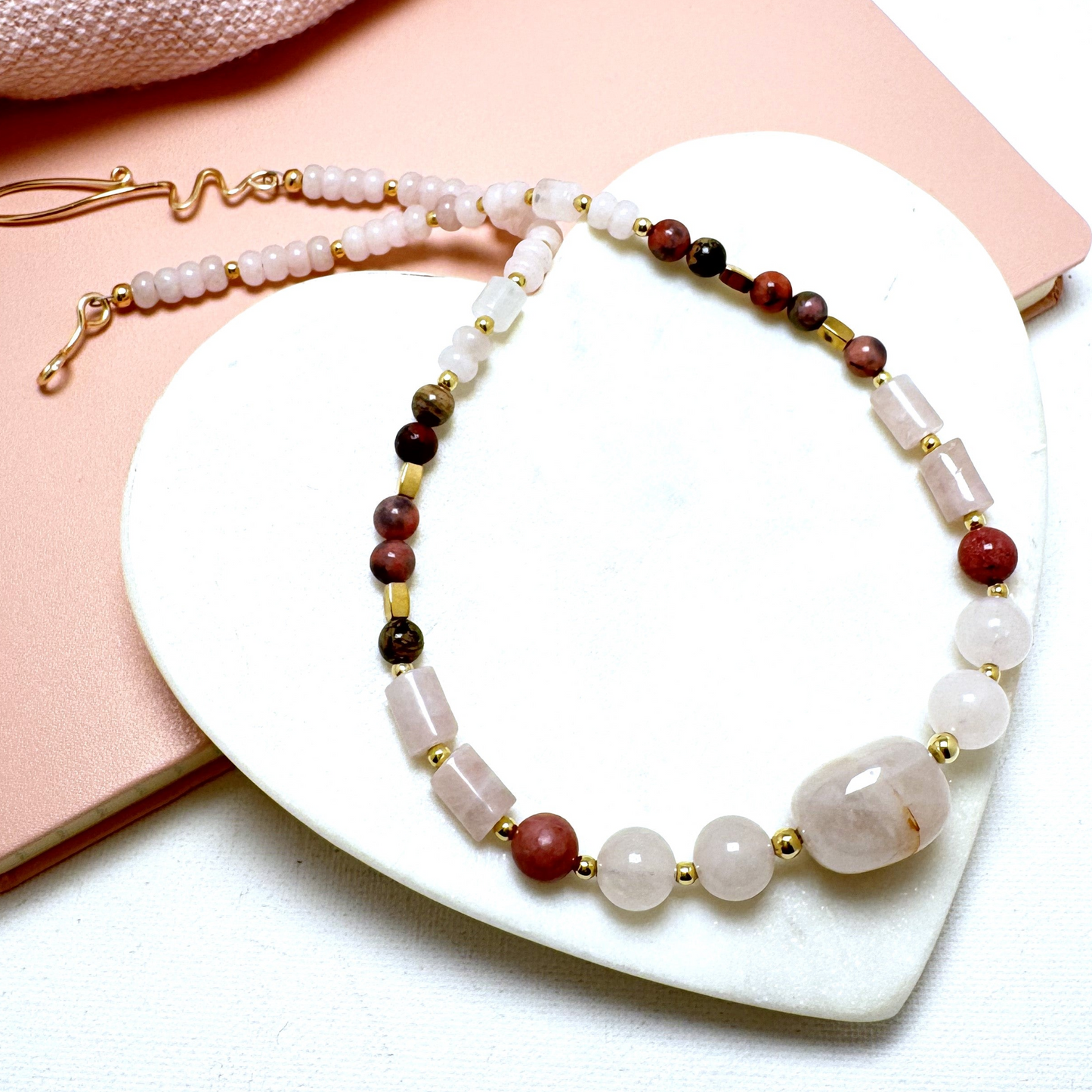 A handcrafted 19-inch necklace featuring soft rose quartz and rich rhodonite, accented with gold-tone details and a hand-forged hook clasp. A timeless piece symbolizing love and compassion, perfect for Valentine's Day or any special occasion.