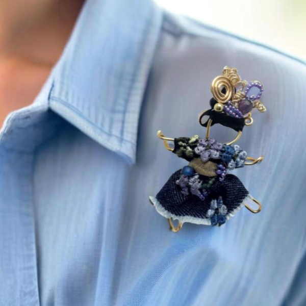 The Pixie Pin is a whimsical handmade brooch featuring denim with delicate embroidered flowers, capturing the playful and creative spirit of the pixie realm. A charming accessory for jackets, scarves, or bags.