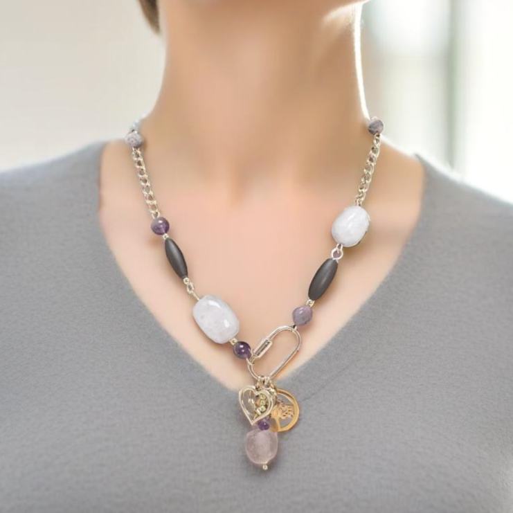 A blend of organic beauty and contemporary design, this necklace features rose quartz, amethyst, and agate beads with delicate chain elements. A stylish carabiner has three symbolic charms: a Tree of Life, a heart, and pink sea glass . Thoughtfully handcrafted