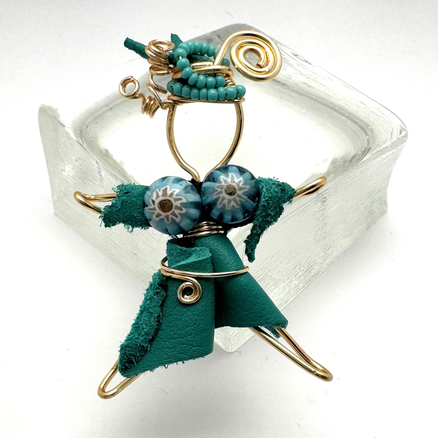 A handcrafted Pixie Pin brooch made from soft turquoise suede, featuring a whimsical design that embodies creativity and nature-inspired charm. Made in Canada with recycled materials.