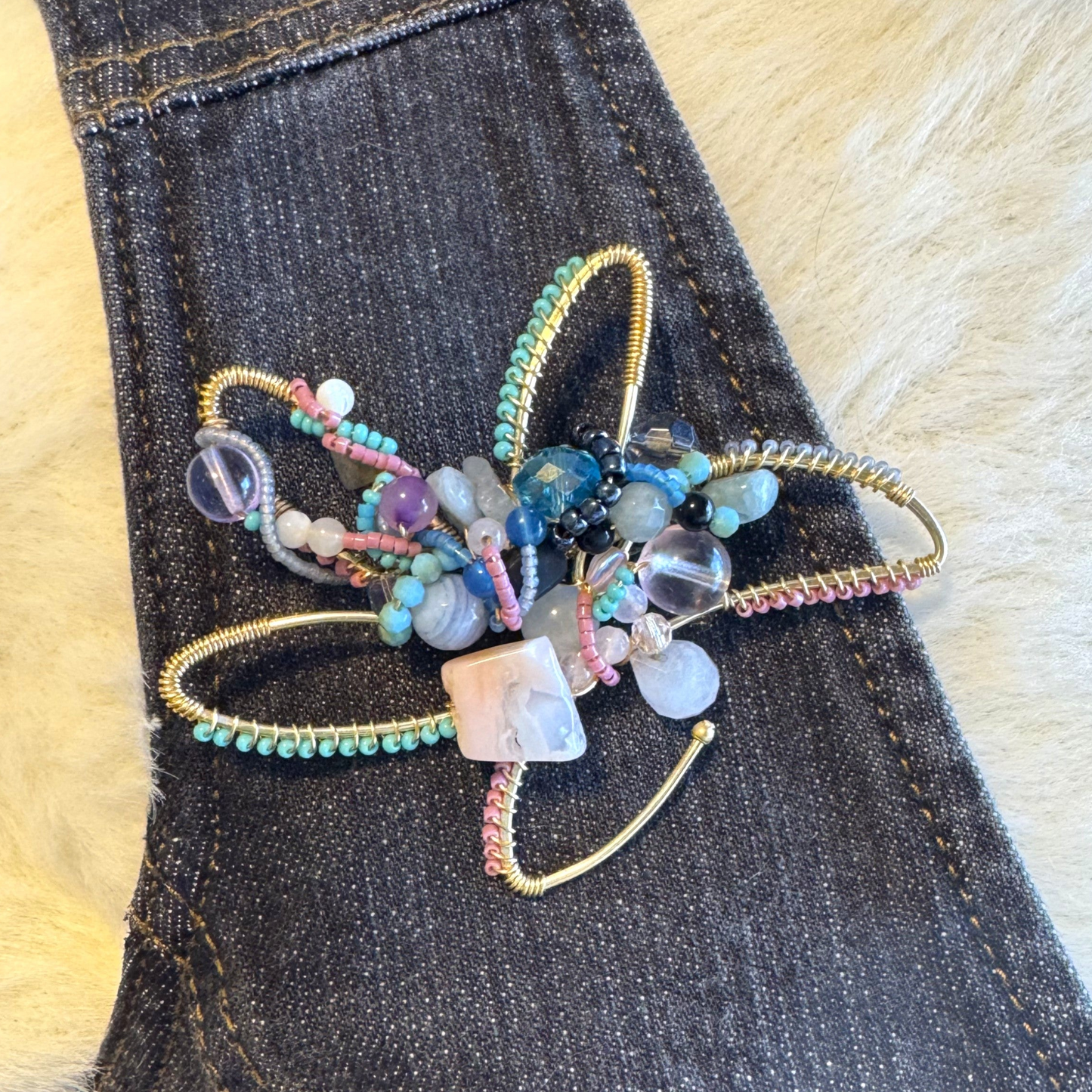Decorative artisan brooch with beads on a denim jacket