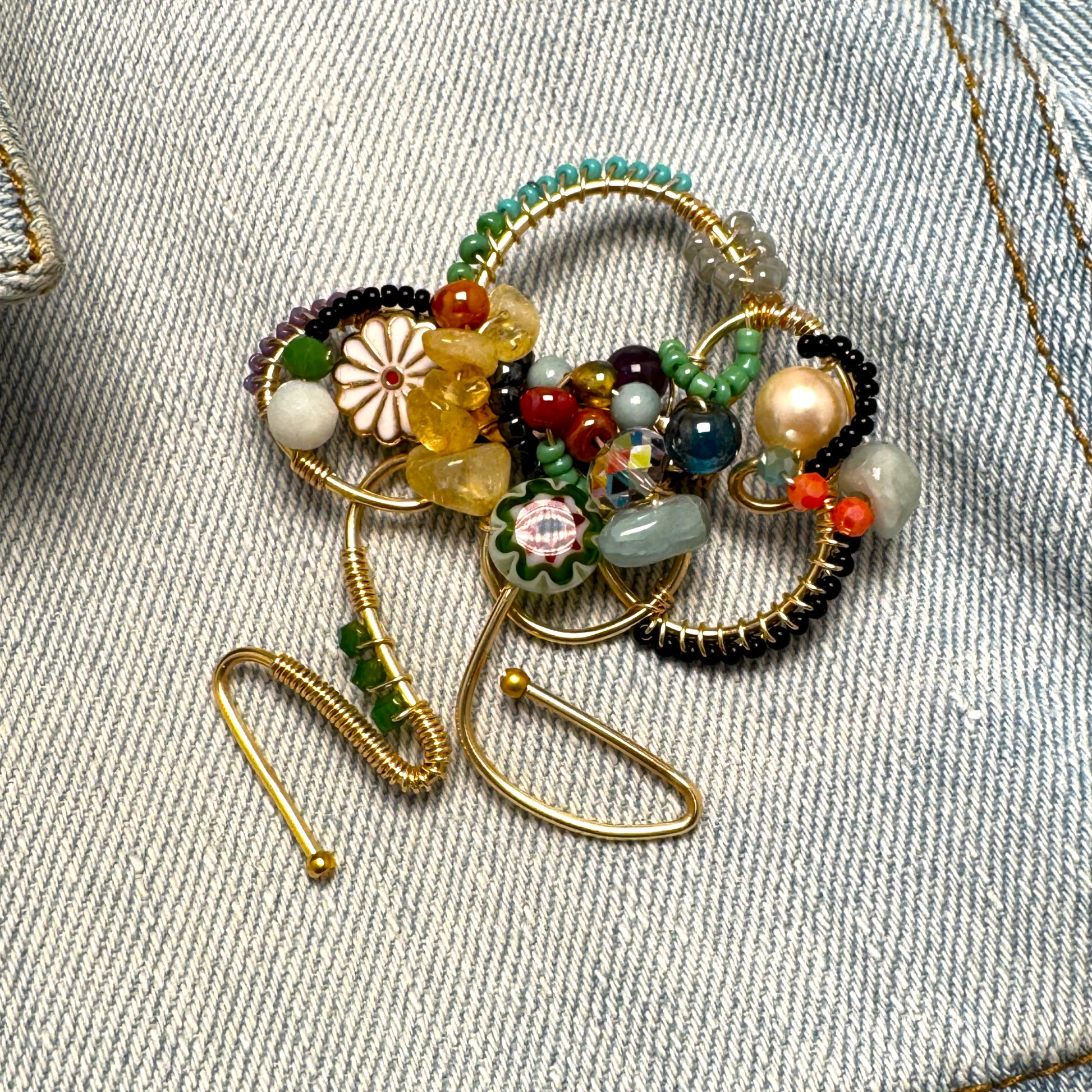 Decorative brooch with beads on a denim background