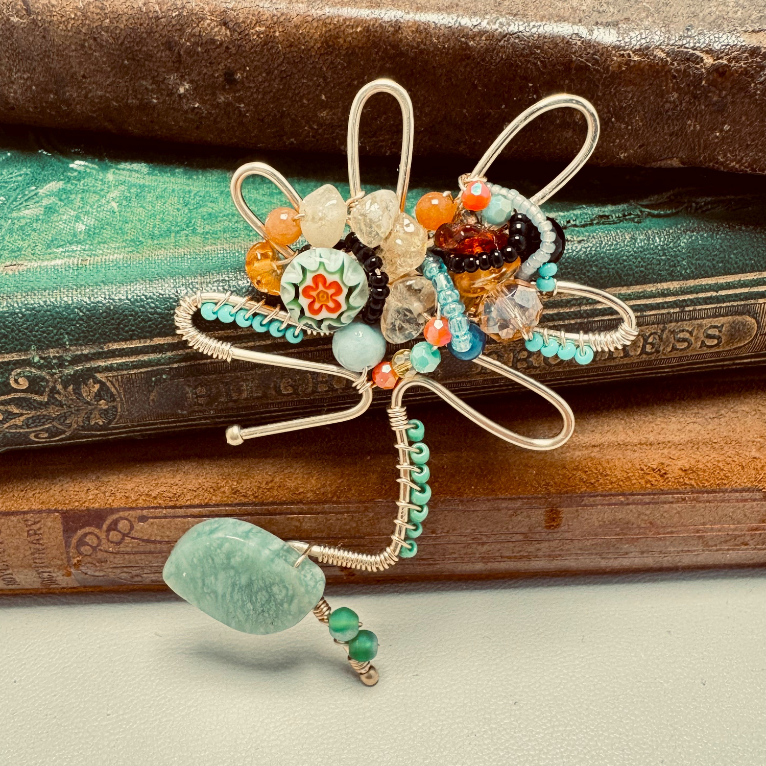 Decorative brooch with beads on a textured surface