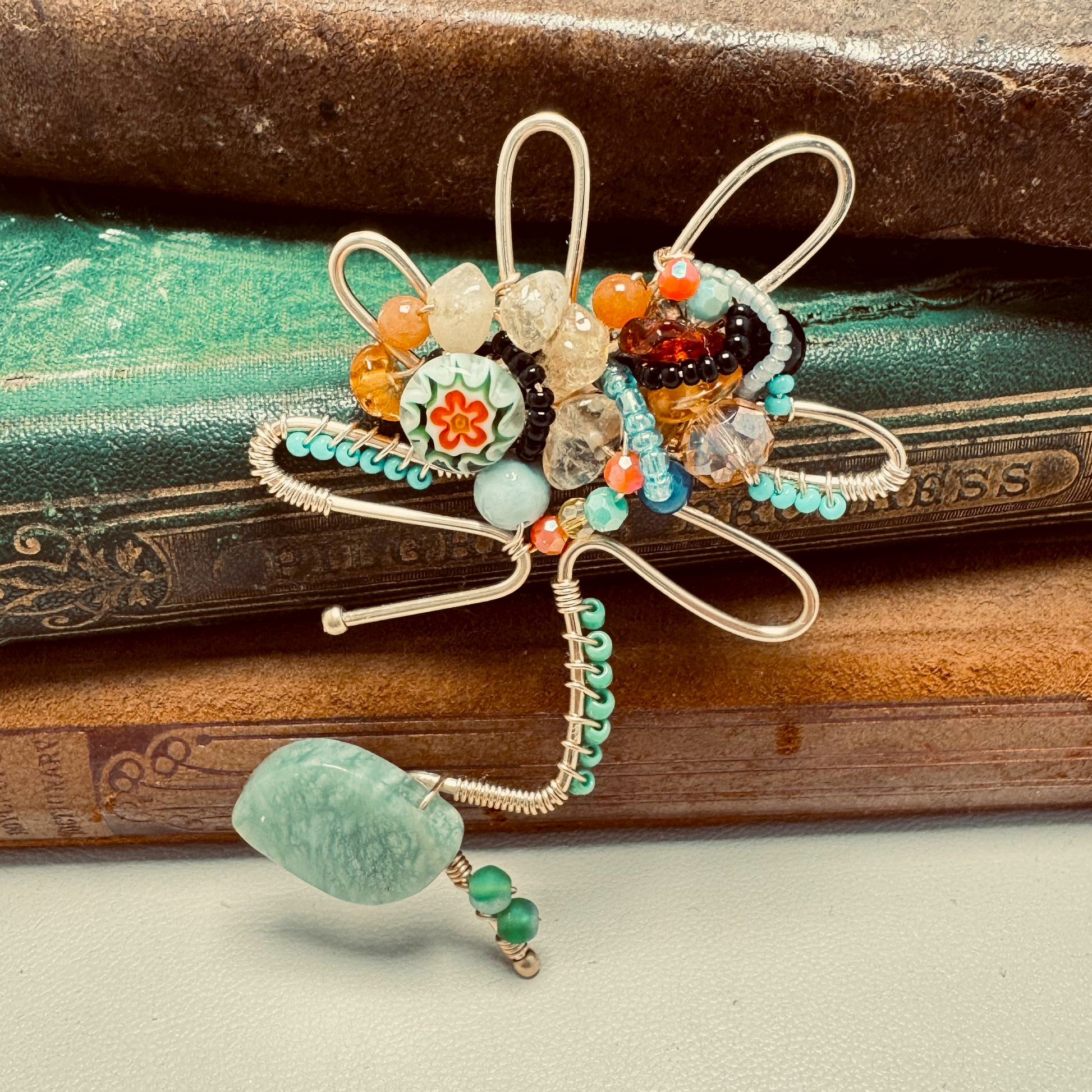 Decorative brooch with beads on a textured surface