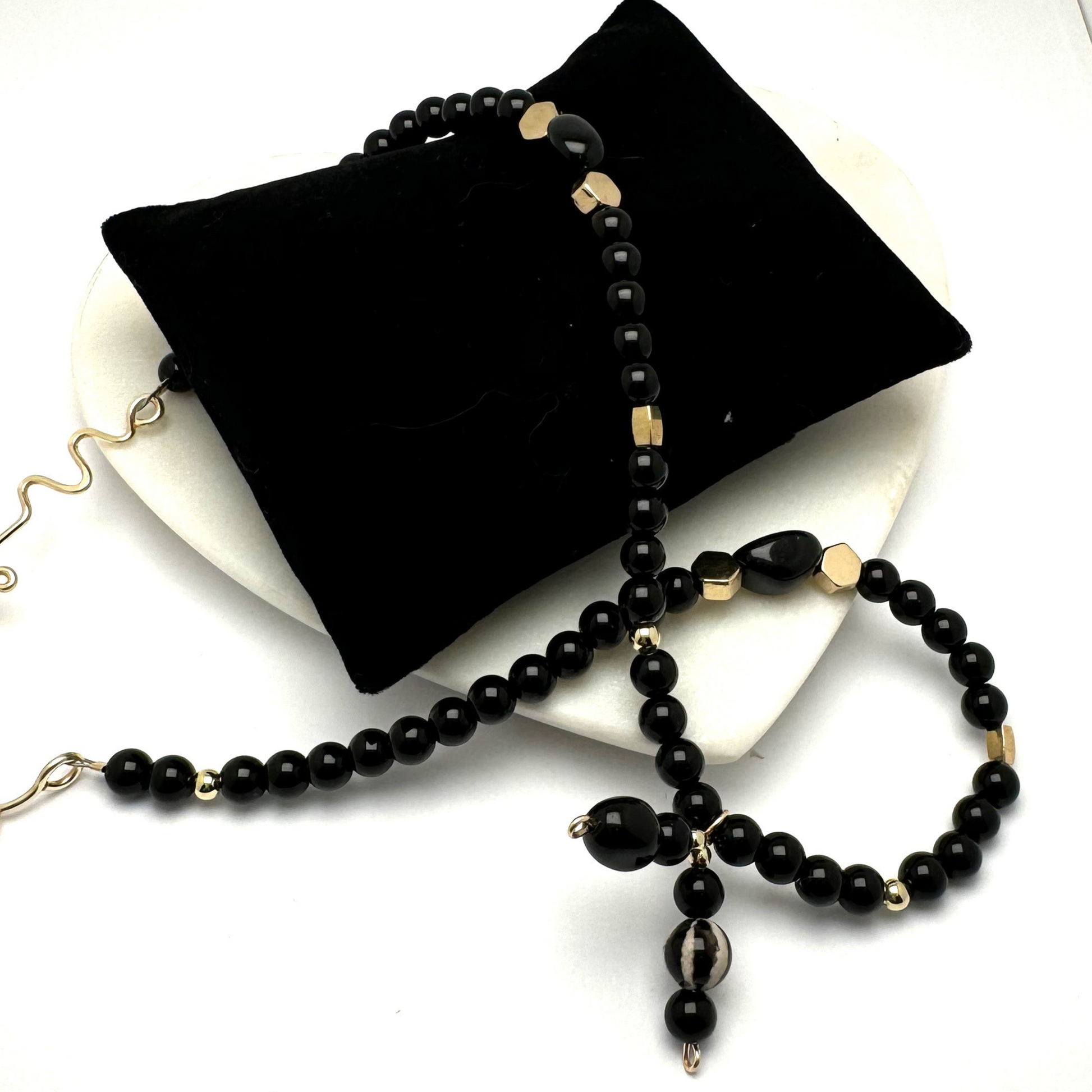 A handcrafted 18-inch black agate necklace featuring a stylish front-tie detail and a signature handmade hook clasp. Designed for versatility, this elegant piece is believed to dispel negative energy while promoting happiness and harmony. A timeless accessory by Lacey & Bohème, perfect for any occasion. Handmade in Canada.