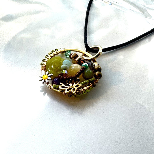 Necklace with a circular pendant featuring beads and a small yellow flower on a white background