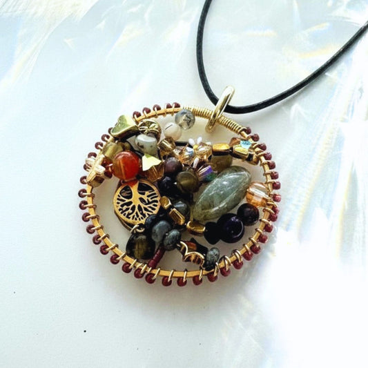 Decorative necklace with multicolored beads and a tree of life charm on a white background