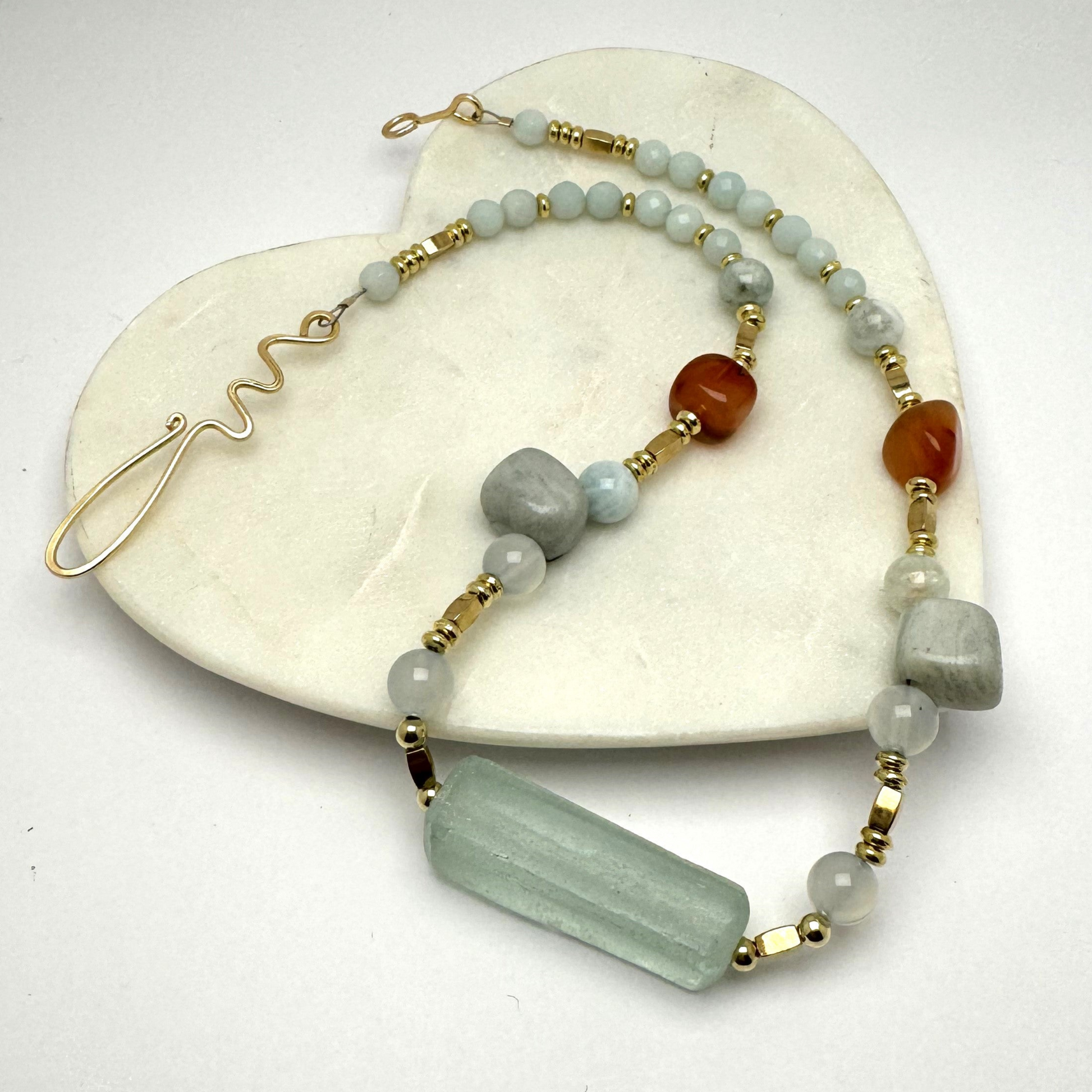 A handcrafted 18.5-inch necklace featuring soft-toned quartz, green aventurine, and warm amber-hued carnelian stones, accented with gold details. Designed for balance, prosperity, and grounding, this artisanal piece includes a unique handmade hook clasp. Thoughtfully crafted by Lacey & Bohème, perfect for adding positive energy and elegance to any outfit. Made in Canada.