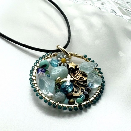 Handmade Halo pendant with aqua and turquoise stones, crystals, tree of life charm, and black cord necklace.