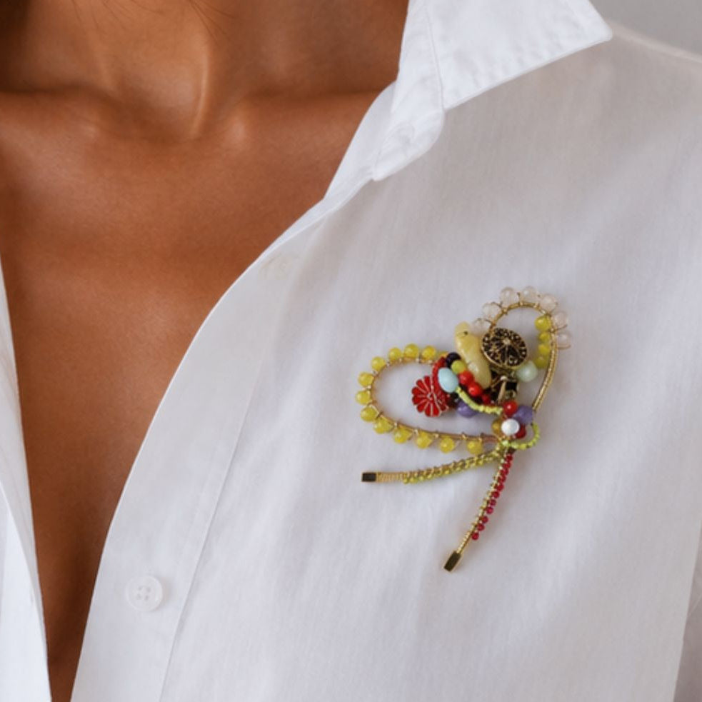 Close-up of a colorful brooch on a white shirt