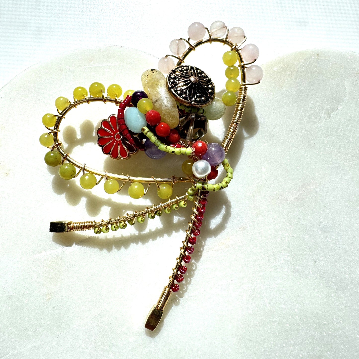 wire, beaded brooch on a white background